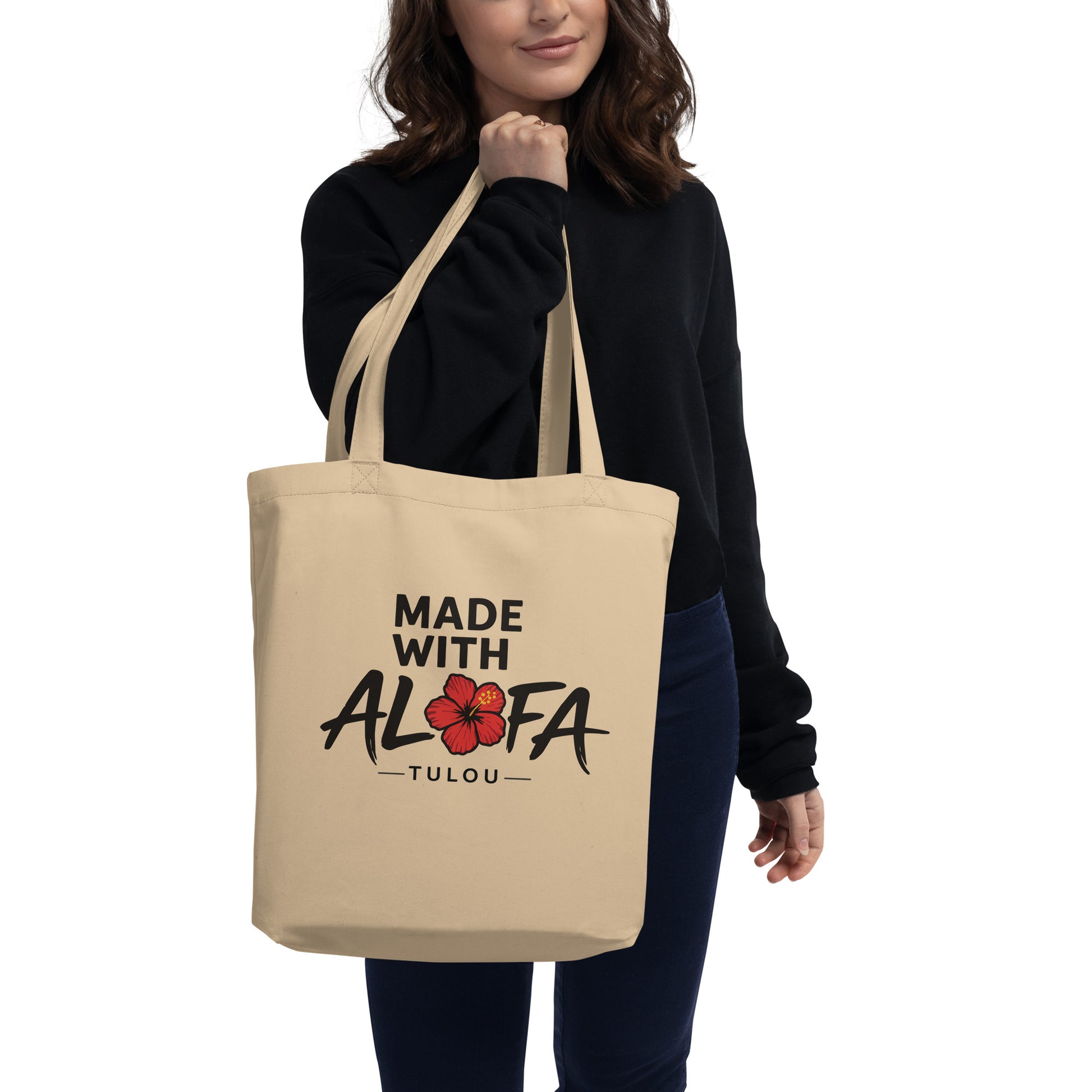 Person holding a beige tote bag with a design on a white background