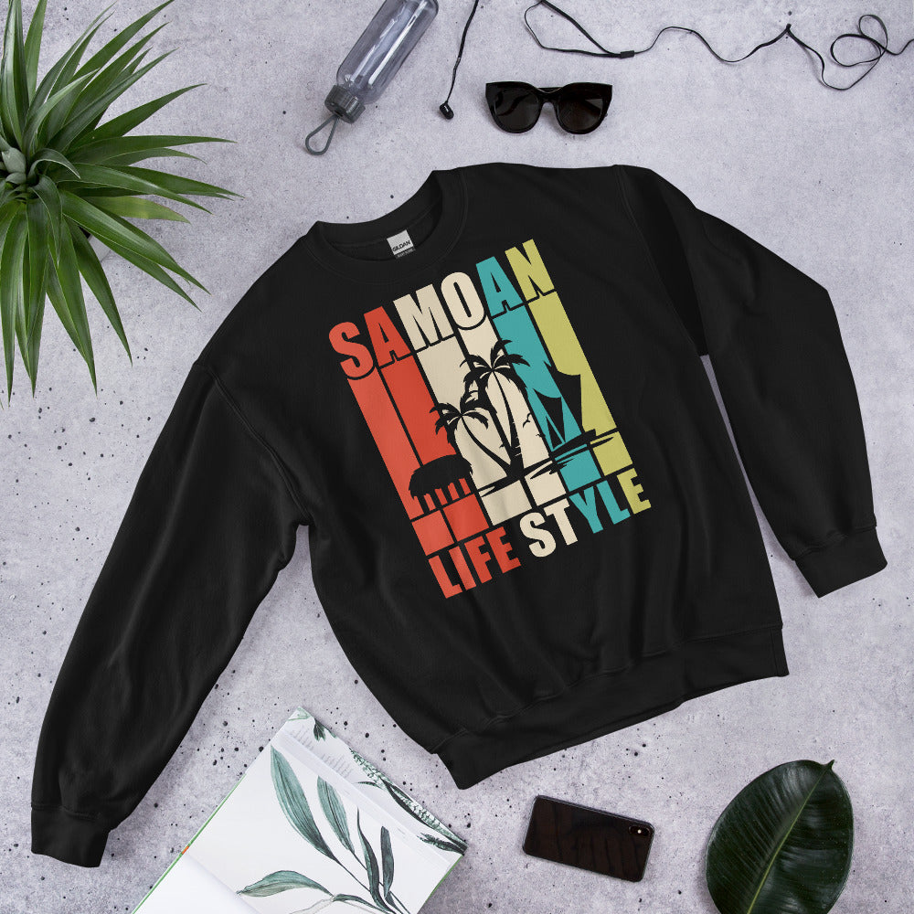 Black sweatshirt with 'Samoan Lifestyle' design on a gray surface with plants and sunglasses.